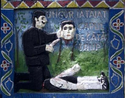 An image is seen painted on the cross of a grave of a beheaded man in the Merry Cemetery of Sapanta, northwest of Bucharest, in this July 3, 2004 file picture. Bursting with colour, life and history, hundreds of brilliantly decorated wooden crosses have marked the graves of villagers since an imaginative local wood carver started this unique tradition in the 1930s.    REUTERS/Bogdan Cristel/FEATURE/ROMANIA-CEMETERY